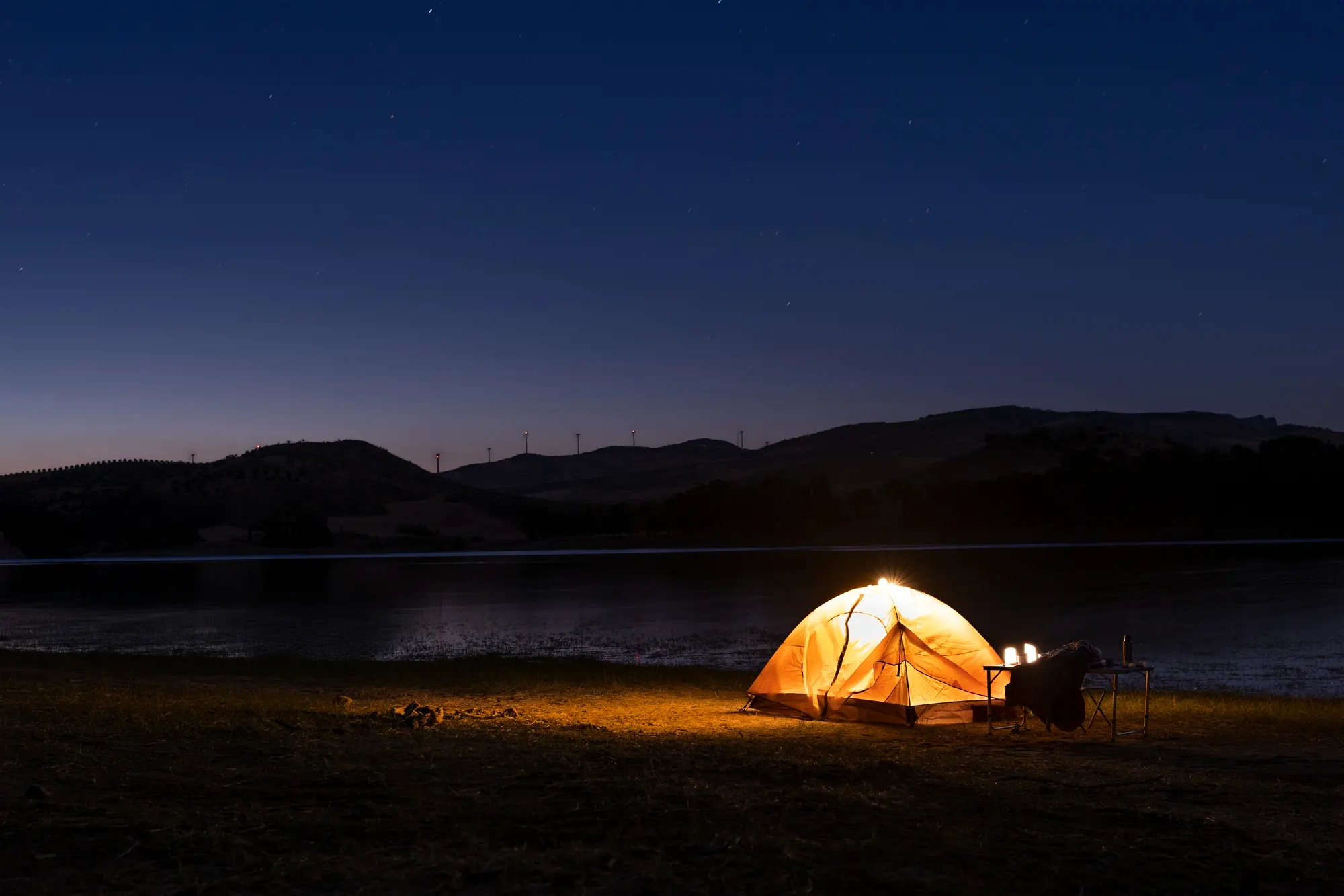 Canvas expedition tent overlooking misty alpine mountains at dawn
